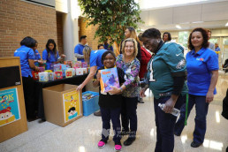크리스티아나 병원 소아과 진료소에서 도서 기증을 위해 봉사하는 국제WeLoveU 회원들의 모습과 기쁨과 설렘으로 책을 받은 아이의 모습